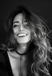 © PrabhjitSingh - Beautiful young woman in her late 20s, smiling with long wavy hair in a high contrast black and white photograph. Timeless and elegant portrait