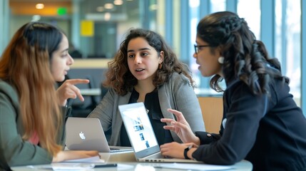 Sticker - Three people are sitting at a desk with a laptop open One of the women is pointing at the laptop screen Scene is collaborative and focused : Generative AI