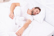 © be free - Man sleeping at night. Sleepy man lying on bed sleeping at white bedroom. Asleep young man sleeping. Resting peacefully in comfortable bed. Lying with closed eyes. Deep male sleep