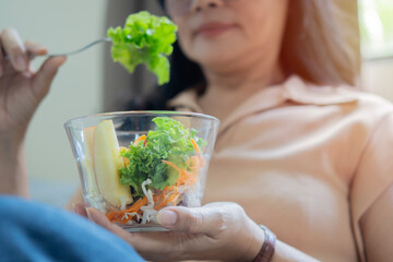 Closeup of a adult woman eating healthy salad . Beautiful smiling woman eating healthy salad