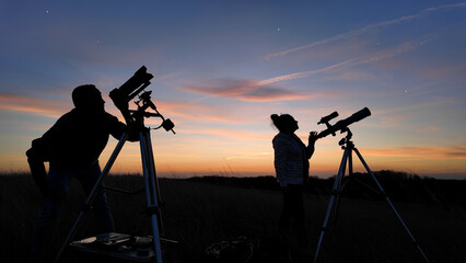 Wall Mural - amateur astronomers looking at the evening skies, observing planets, stars, moon and other celestial