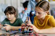© Halfpoint - School girls working on circuit board of small robot, building robotic car in after-school robotics club. Children learning robotics in Elementary school. Girls in science.