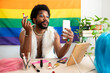 © Westend61 - Gay man holding lipstick and talking on video call preparing for pride parade