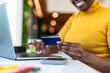 © Westend61 - Hand of businesswoman holding credit card at office