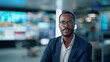 © NaphakStudio - A confident African American male news anchor in a high-tech studio, surrounded by screens displaying vibrant graphics and news tickers.