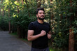 © Vitaliy - Portrait of sporty and handsome man in black sportswear walking in the eco park. Healthy lifestyle and running in open air concept