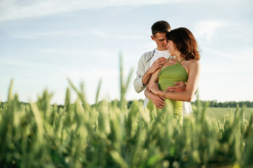 Wall Mural - Standing and enjoying nature and each other. Lovely couple are on the agricultural field together