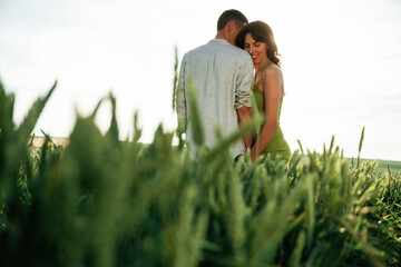 Wall Mural - Under the sunlight, enjoying each other. Lovely couple are on the agricultural field together