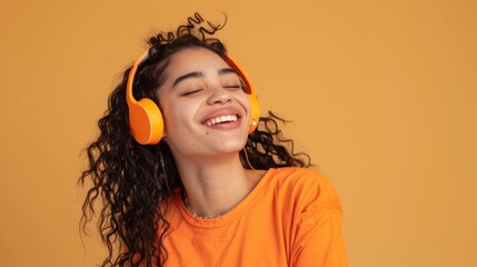 Wall Mural - A young woman wearing headphones and laughing, ideal for use in a variety of settings, from social media to advertising campaigns