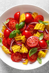 Wall Mural - Tomato and corn salad with fresh basil, onion, dressed with olive oil. Mexican food, tomato corn salad Esquites, top view