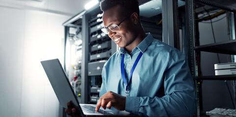 Wall Mural - Laptop, server room and black man on network for database maintenance, programming software or typing. Tech, data center and happy engineer on system for information, cybersecurity or cloud computing