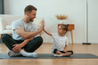 © standret - Father with little daughter are doing yoga at home
