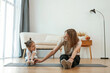 © standret - Young woman with little girl are doing yoga at home