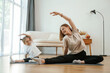 © standret - To the side, stretching. Young woman with little girl are doing yoga at home