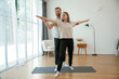 © standret - Man and woman are doing yoga exercises at home