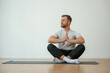 © standret - Yoga man is sitting on a mat at home