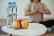 © standret - Young woman is sitting on the yoga mat. Conception of healthy eating, apples