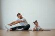 © standret - Teaching how to stretch the legs. Father with little daughter are doing yoga at home