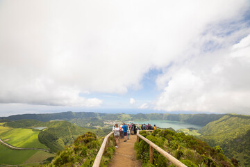 Wall Mural - A group of people are walking on a path up a mountain