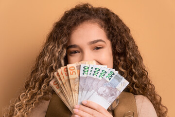 excited caucasian woman celebrating successful business money in all beige colors. business, loan, pay, wealth concept. 