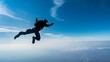 © TawaUStock - Side angle view, black silhouette of a person skydiving, open sky background, free-fall position