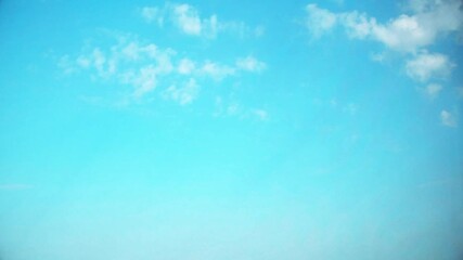 Wall Mural - Bright blue sky with small, fast moving clouds. Background with an atmospheric theme in soft, pastel colors.