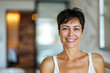 © Lazy_Bear - Middle-aged woman with short dark hair smiles in contemporary home.