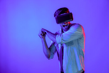 Wall Mural - Caucasian man wearing VR glass and moving gesture holding sword. Gamer using future digital virtual reality headset or futuristic innovation to enter meta world or playing action game. Deviation.