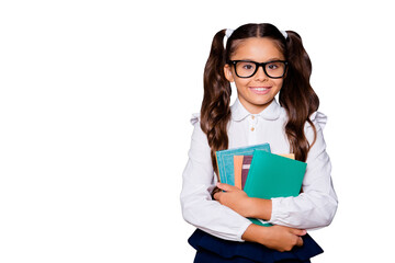 Sticker - Glad positive nice smart cute small little girl with curly pigtails in white blouse shirt and blue skirt, carrying, keeping, hugging big book pile, copy-space. Isolated over black background