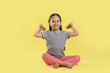 © New Africa - Cute little girl with dumbbells on yellow background