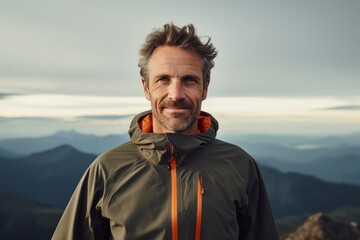 Poster - Portrait of a glad man in his 40s wearing a functional windbreaker isolated in panoramic mountain vista