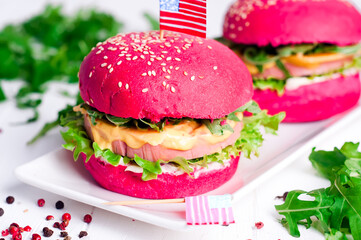 two tasty hamburgers with little American flags