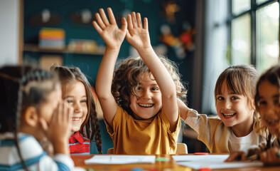 Happy multiethnic children high-fiving after finishing schoolwork together at desk in bright classroom