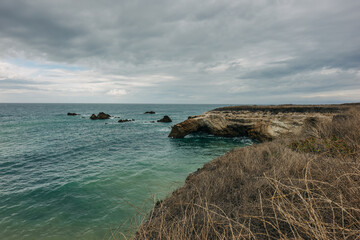 Wall Mural - Sunset over the Pacific ocean. Rocky beach and dramatic cloudy sky, California