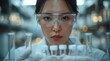 © earthstudiotomo - Scientist wearing safety goggles and gloves, examining test tubes in a laboratory setting, focused on a scientific experiment.