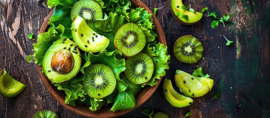 Poster - Avocado kiwi salad with lettuce mix, perfect for a healthy meal or snack, displayed on a rustic table with a top view, ideal for food backgrounds, featuring ample copy space for text.