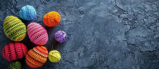 Aufkleber - Top view of colorful knitted Easter eggs set against a stone background, showcasing a handmade holidays decorations concept with plenty of copy space image.