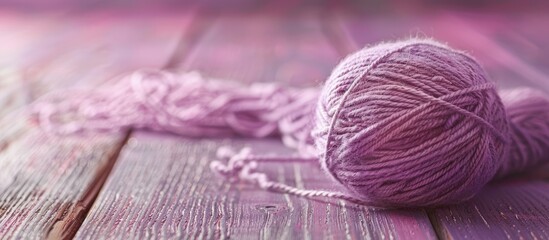 Engaging in knitting as a hobby with a background of a skein of pale lilac wool thread on a wooden table creates a serene and inviting atmosphere for a copy space image.