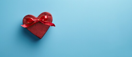 Fototapete - Top-down view of heart-shaped gift box on blue backdrop, conveying a concept for holiday greeting cards with copy space image.