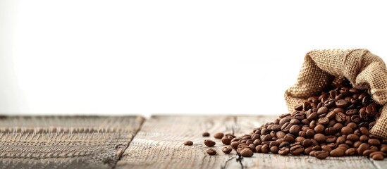 Poster - Coffee beans roasted displayed in a jute sack on a wooden table, set against a white background, with space for text or images. Copy space image. Place for adding text and design