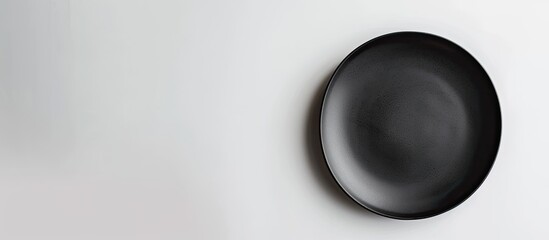 Aufkleber - Black plate on a white backdrop with copy space image.