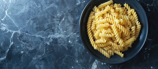 Poster - Macaroni in a ceramic dish on a black marble surface with copy space image.