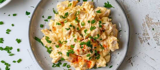 Wall Mural - Low-angle view of a plate with homemade Coronation Chicken Salad on a white background, providing space for additional image elements.