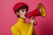 © Bora1710 - Stylish Woman with Megaphone in Bright Yellow Turtleneck and Red Hat