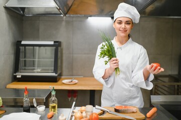 cooking and food concept. smiling female chef, cook or baker chopping vegetables