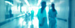 © Pink Badger - Back lit blurred rear view of nurses in a hospital corridor, defocused, indistinct backdrop of a clinical setting.