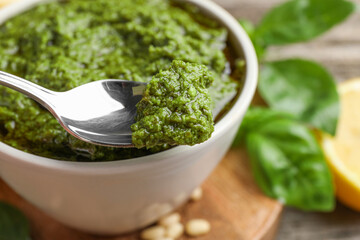 Taking tasty pesto sauce at table, closeup