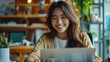 © FATNA - Happy young woman working remotely on virtual video team meeting call, remote work and flexible culture concept, smiling asian female digital nomad freelancing on laptop from home, copy space