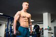 © vladim_ka - A muscular man lifts weights in a gym during a workout session