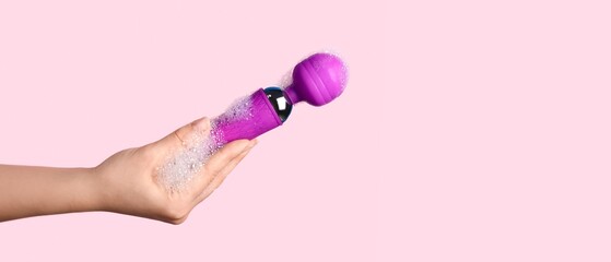 Wall Mural - Woman washing vibrator on pink background with space for text